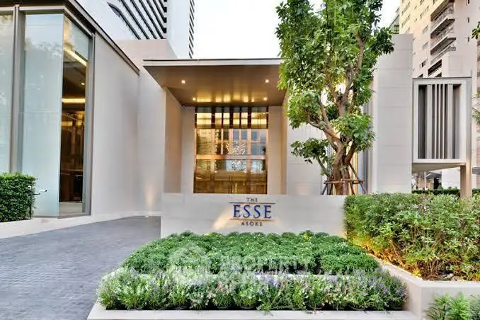 Luxurious modern building entrance with lush greenery and elegant design at The Esse Atoki.