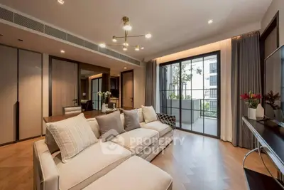Luxurious living room with modern decor and spacious balcony access in upscale apartment.