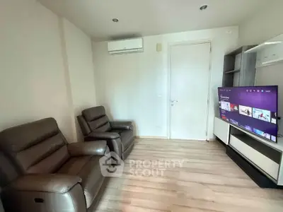 Cozy living room with modern recliners and wall-mounted TV, perfect for relaxation.