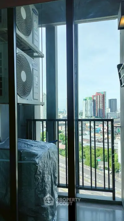 High-rise apartment balcony with city view and air conditioning units.