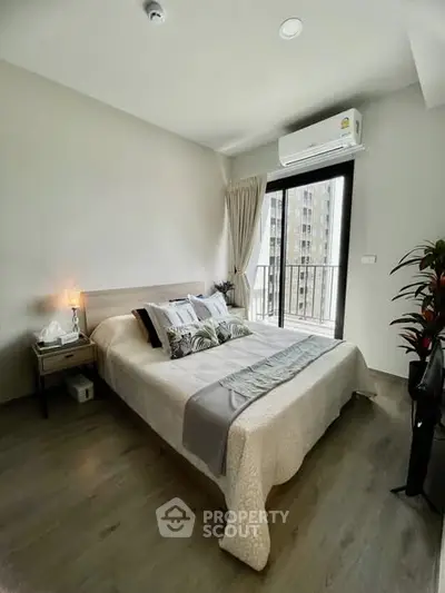 Modern bedroom with balcony access and air conditioning in a stylish apartment.
