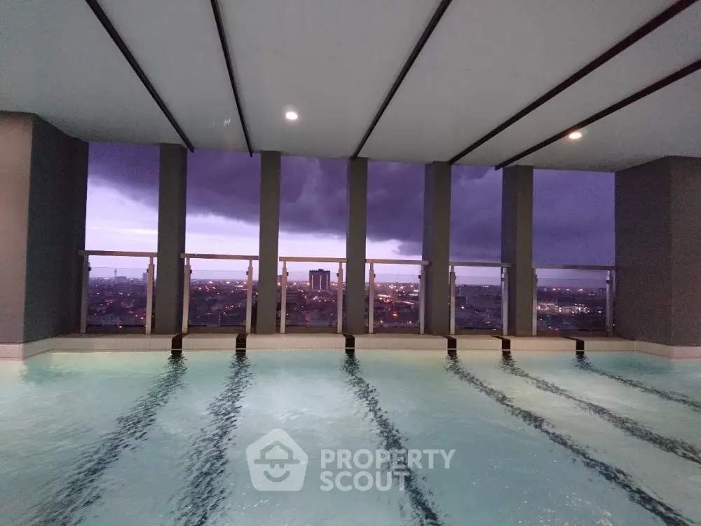 Luxurious rooftop pool with stunning city view at dusk, perfect for relaxation and leisure.