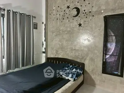 Cozy bedroom with celestial-themed decor and large window