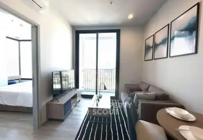 Modern living room with stylish decor and balcony access in a cozy apartment.