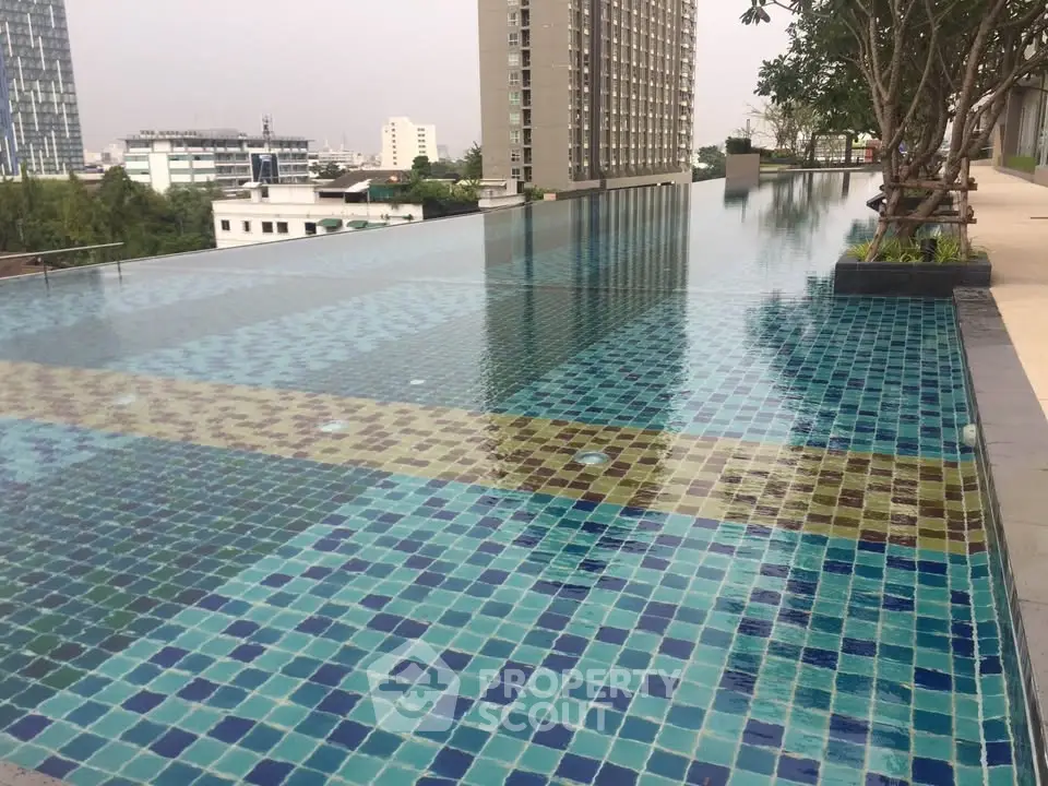 Stunning rooftop infinity pool with cityscape views in modern residential complex.