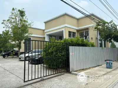 Modern residential building with gated entrance and parking area