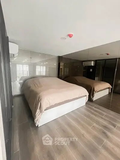 Modern bedroom with mirrored walls and wooden flooring