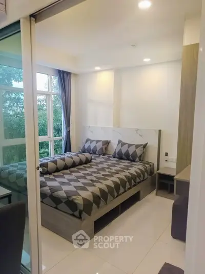 Modern bedroom with large windows and stylish decor in a cozy apartment.
