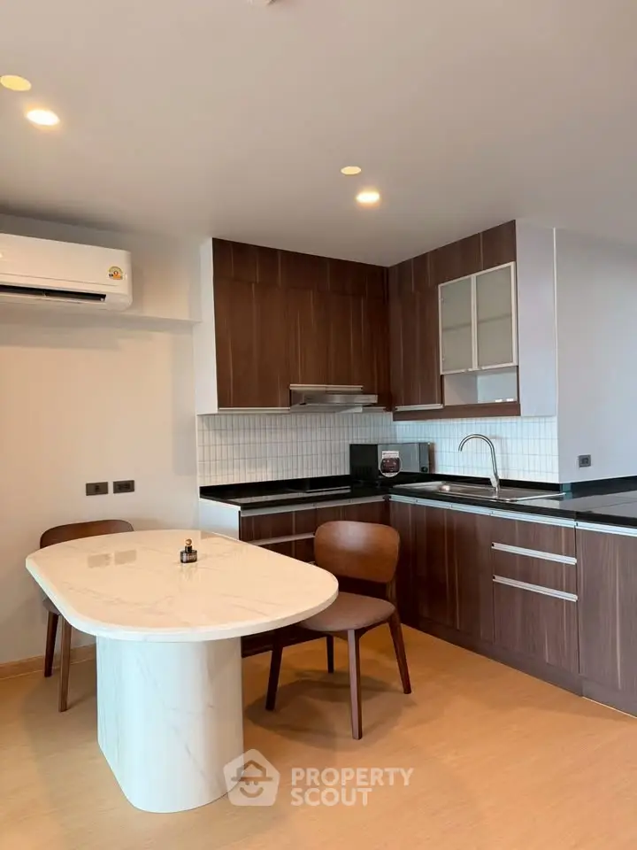 Modern kitchen with sleek wooden cabinets and elegant dining area in a stylish apartment.
