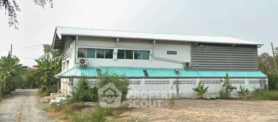 Spacious industrial-style building with metal roof and ample outdoor space, ideal for commercial use.