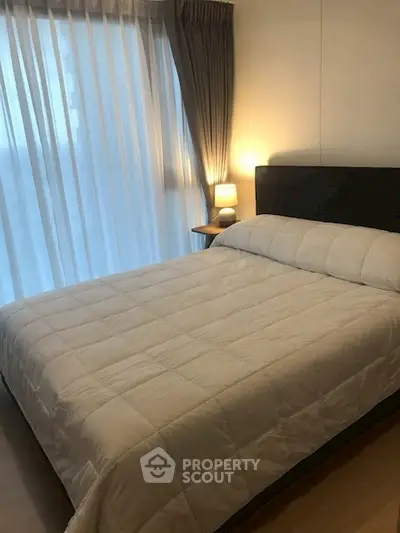 Cozy bedroom with elegant decor and soft lighting, featuring a large bed and floor-to-ceiling window.