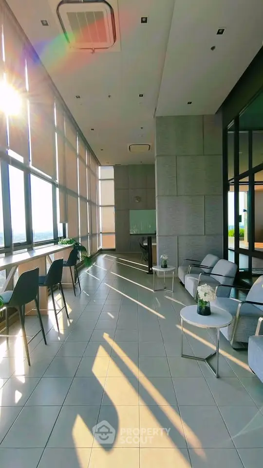 Modern high-rise building lobby with panoramic windows and stylish seating area