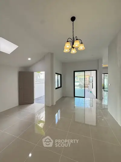 Spacious modern living room with elegant chandelier and large windows