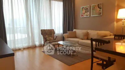 Elegant living room with floor-to-ceiling windows, stylish furniture, and warm lighting.