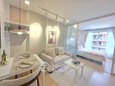 Modern open-plan living room with cozy dining area and sliding glass doors to bedroom.