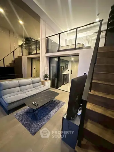 Modern loft-style living room with mezzanine, sleek furniture, and open layout for urban living.