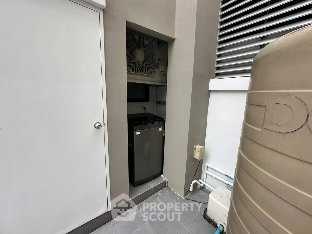 Compact outdoor utility area with air conditioning unit and storage space.