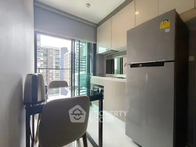Modern kitchen with sleek appliances and city view from window.