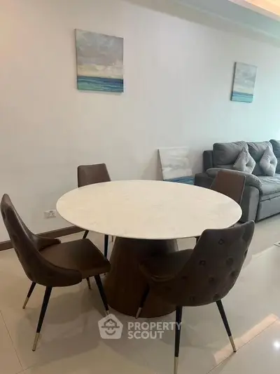 Modern living room with stylish round dining table and elegant chairs, perfect for cozy gatherings.