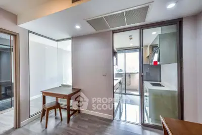 Modern apartment interior with glass partition and sleek kitchen design