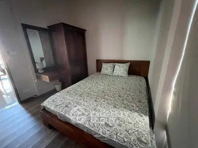 Cozy bedroom with wooden furniture and patterned bedding in a well-lit space.