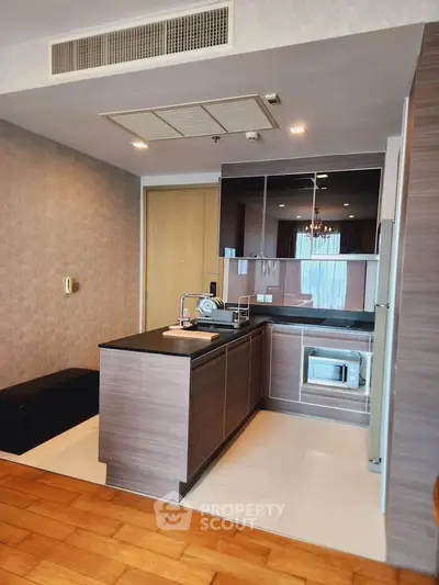 Modern kitchen with sleek cabinetry and built-in microwave in stylish apartment.