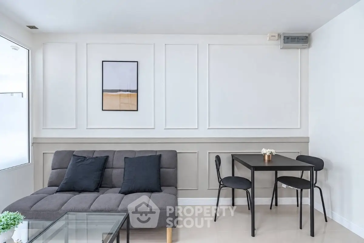 Modern living room with stylish sofa and dining table in a minimalist design.