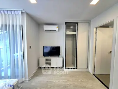 Modern living room with sleek design, featuring air conditioning and TV setup, perfect for urban living.
