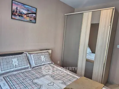 Cozy bedroom with stylish wardrobe and framed cityscape art, perfect for modern living.