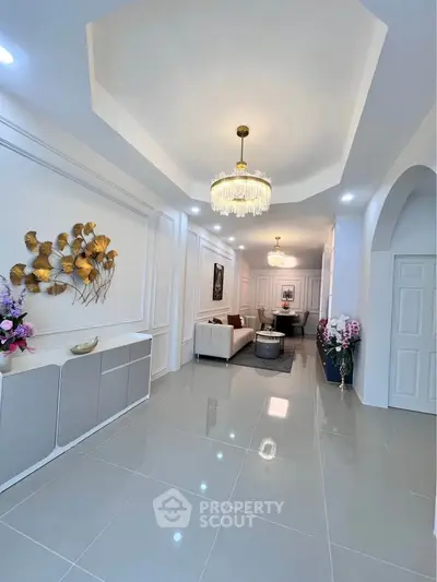 Elegant living room with modern chandelier and stylish decor in a spacious open layout.