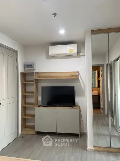 Modern living room with sleek TV setup and mirrored wardrobe