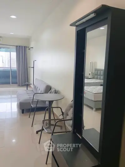 Modern studio apartment with sleek furniture and balcony access, perfect for urban living.