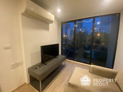 Modern living room with city view, sleek furniture, and air conditioning unit.