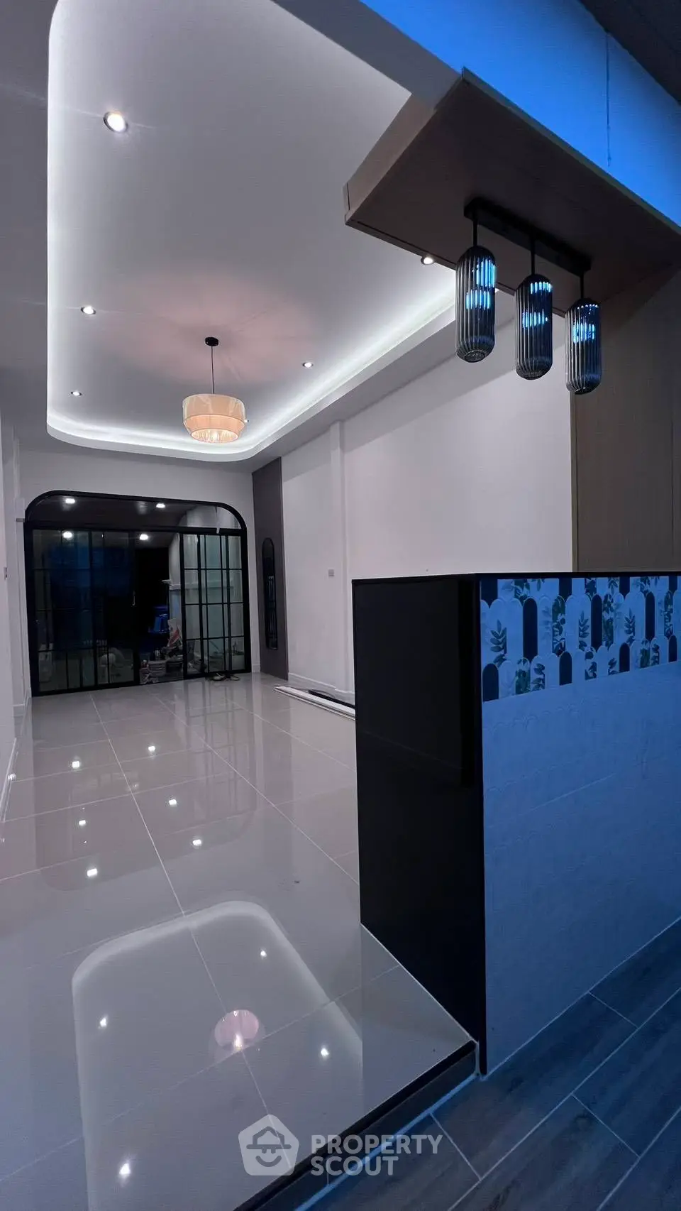 Modern living room with sleek lighting and glossy tiled flooring