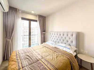 Cozy bedroom with modern decor and large window offering city view