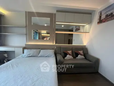 Modern studio apartment with cozy bed and stylish sofa, perfect for urban living.