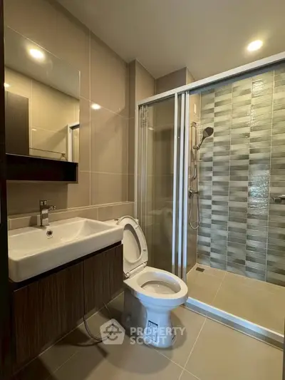 Modern bathroom with sleek shower and stylish vanity in contemporary apartment.