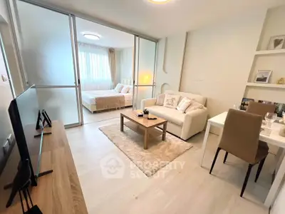 Modern open-plan living room with cozy bedroom view, stylish furniture, and elegant decor.