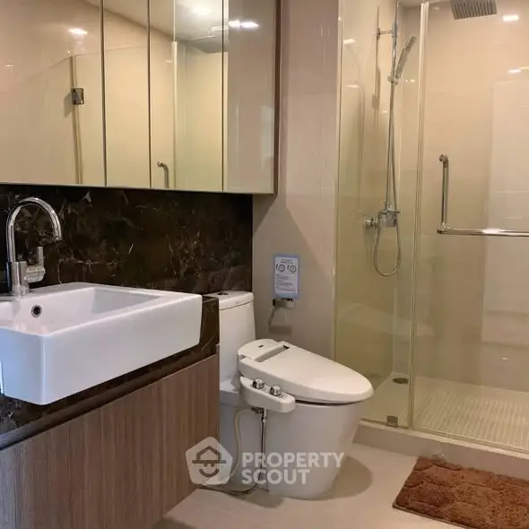 Modern bathroom with sleek fixtures and glass shower enclosure