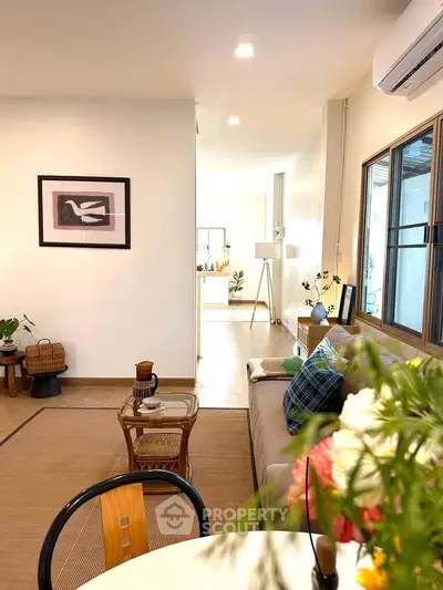 Charming living room with cozy decor and natural light, perfect for relaxation and entertaining.