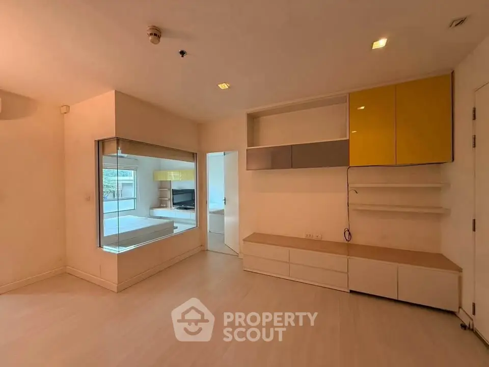 Spacious modern living room with built-in storage and large window