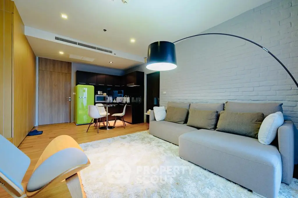 Modern living room with stylish furniture and open kitchen layout in a cozy apartment.