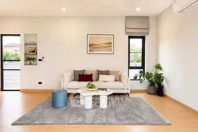 Modern living room with stylish decor, cozy sofa, and large windows offering natural light.
