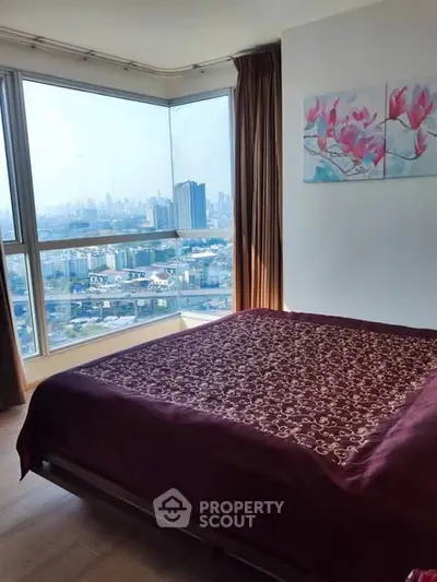 Spacious bedroom with stunning city view and elegant decor in modern apartment.