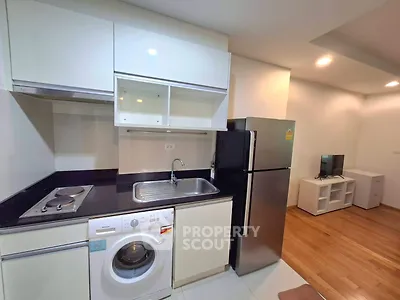 Modern compact kitchen with appliances and washing machine in cozy apartment