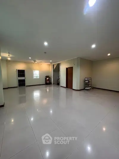 Spacious open-plan living area with glossy tiled floors and modern lighting, perfect for customization.