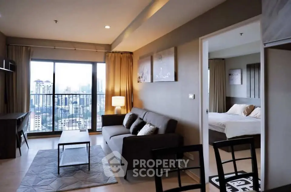 Modern living room with city view, cozy sofa, and elegant decor in a high-rise apartment.