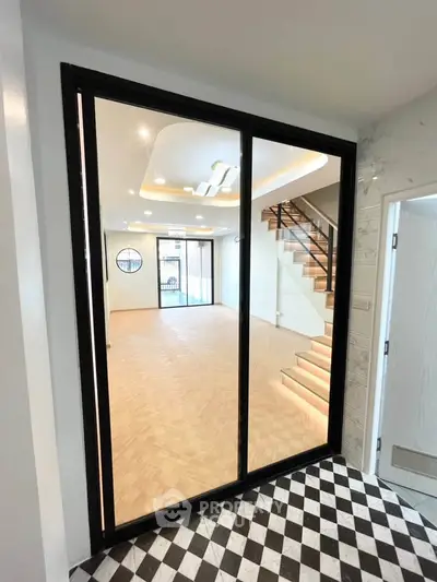 Spacious modern living room with elegant staircase and large windows