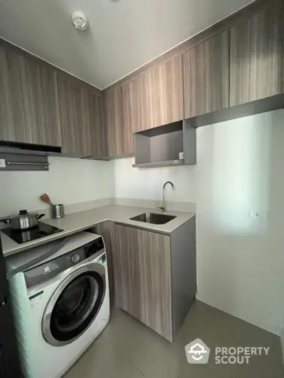 Modern compact kitchen with washing machine and sleek cabinetry