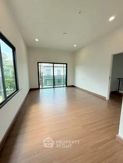 Spacious empty room with large windows and balcony access, perfect for customization.